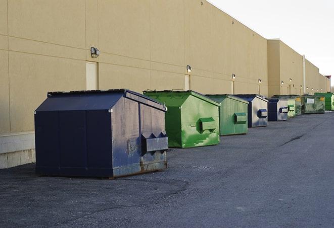 a construction worker empties a wheelbarrow of waste into the dumpster in Bland, MO